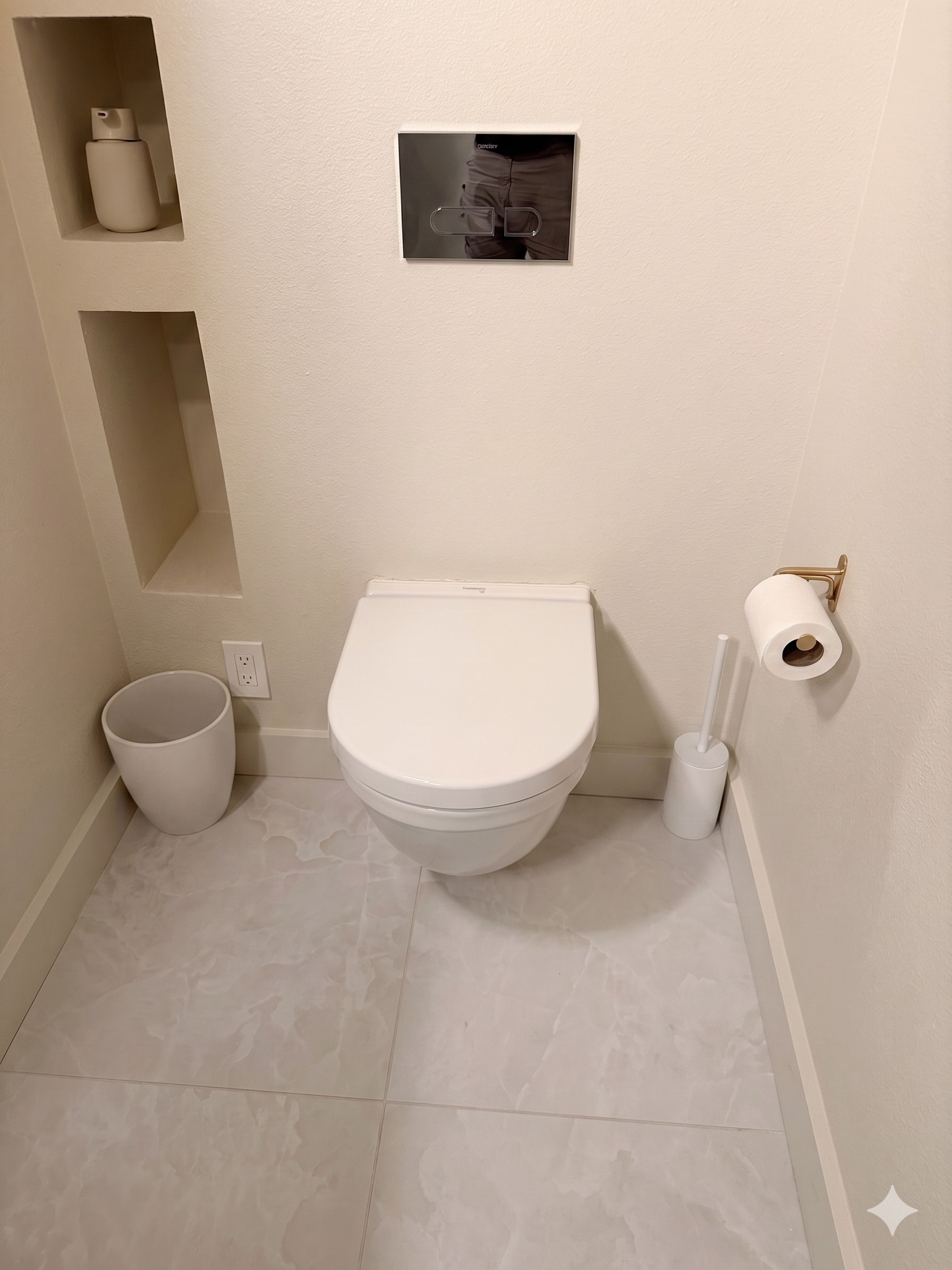 Modern wall-hung toilet with concealed in-wall tank and chrome flush plate
